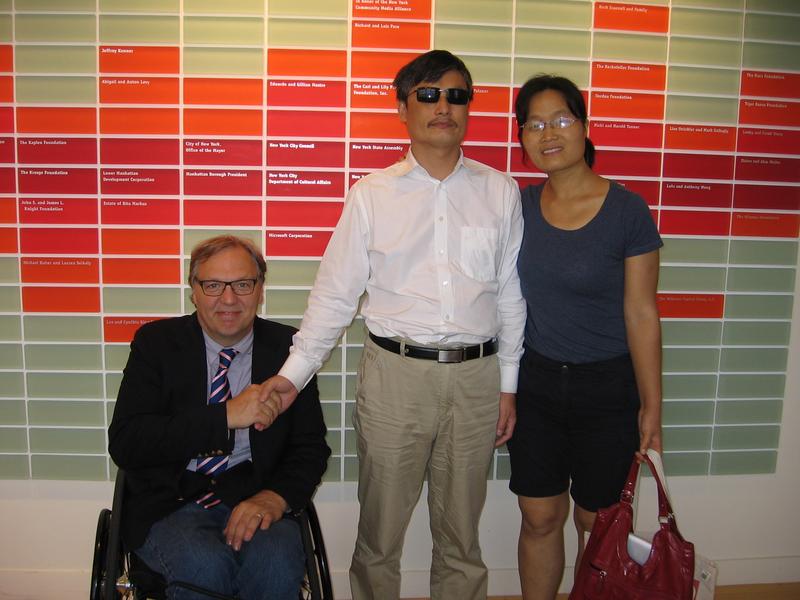 Guangcheng poses with his wife and John Hockenberry.